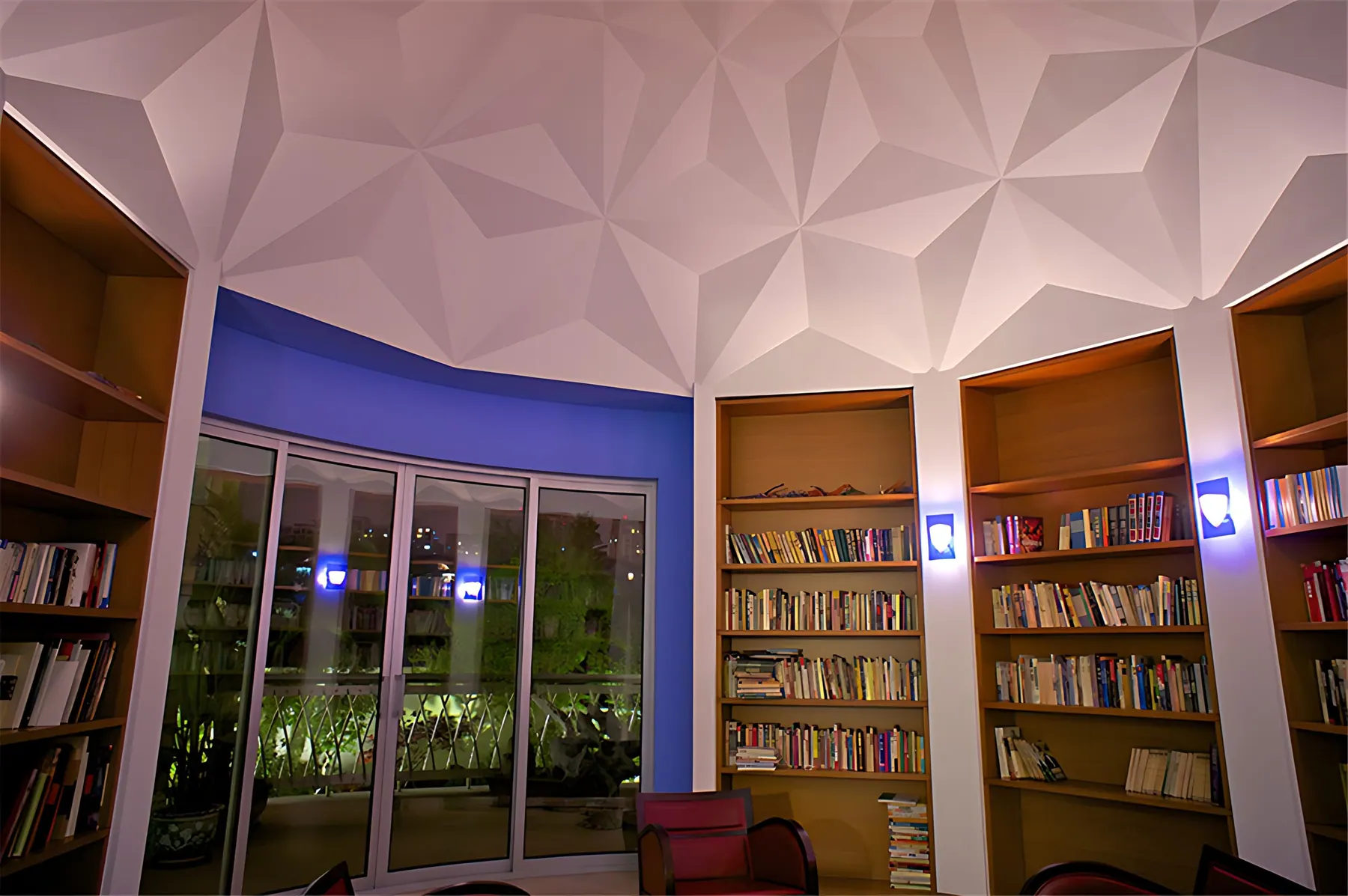 Library with curved bookshelves under a faceted white ceiling at night, Jiujiantang 16 villa, Pudong
