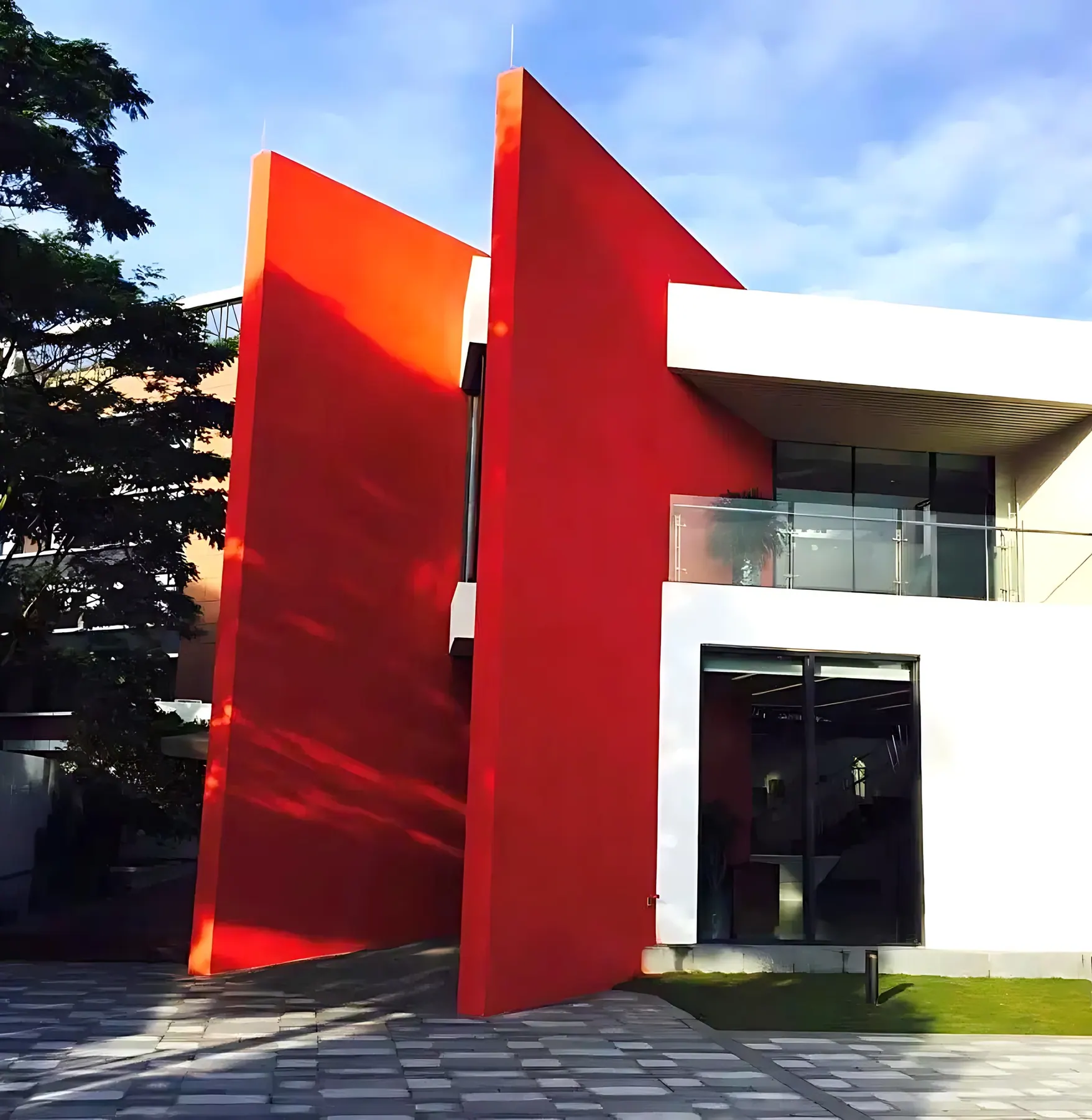 Tall red angled walls against the white facade of the building, U-City Foshan Sales Center